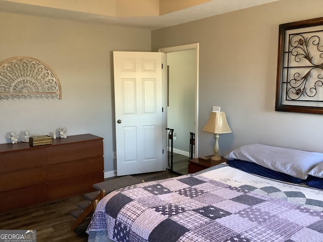 bedroom featuring dark wood finished floors and baseboards