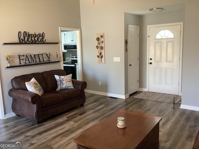 living area with dark wood-type flooring and baseboards