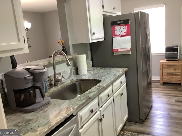 kitchen with white cabinetry, light stone counters, a sink, and stainless steel fridge with ice dispenser