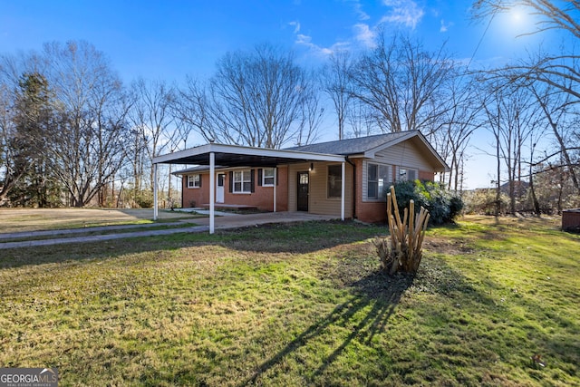 view of front of house featuring a front yard, a carport, and brick siding