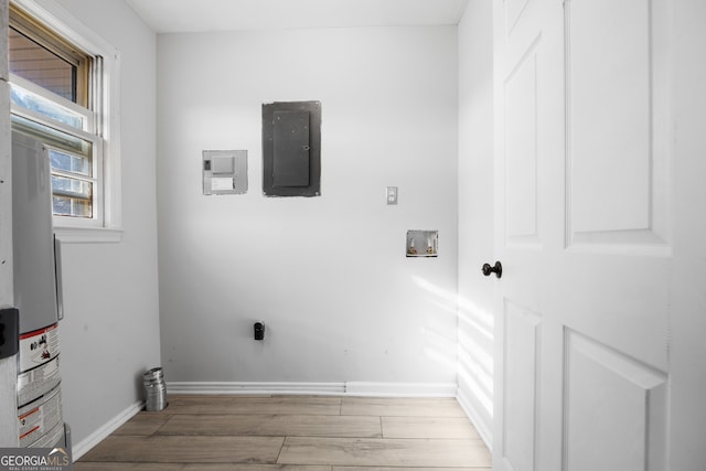 clothes washing area featuring baseboards, laundry area, light wood finished floors, and hookup for an electric dryer