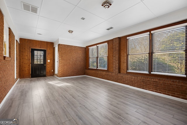 interior space featuring brick wall, visible vents, and light wood-style floors