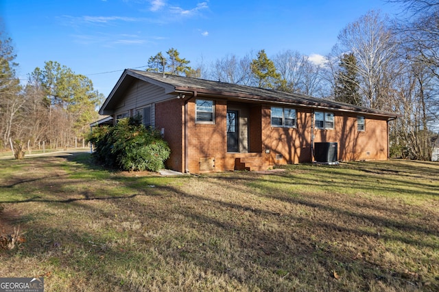 back of property featuring a yard, cooling unit, and brick siding