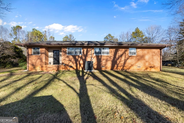 view of front of house featuring crawl space, brick siding, central air condition unit, and a front yard