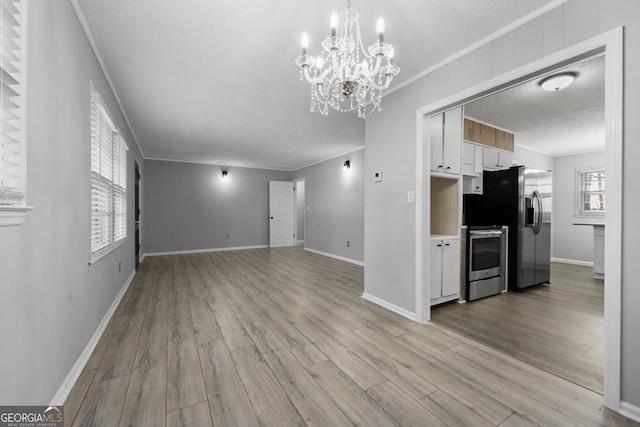 unfurnished living room featuring a textured ceiling, light wood-type flooring, baseboards, and crown molding