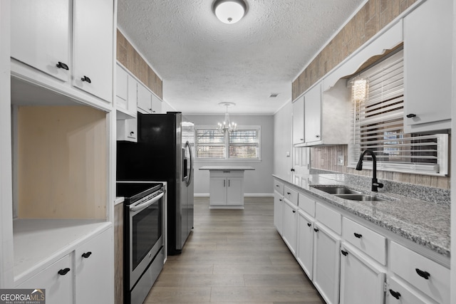 kitchen with pendant lighting, white cabinetry, a sink, and stainless steel electric stove