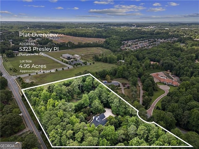 birds eye view of property featuring a view of trees