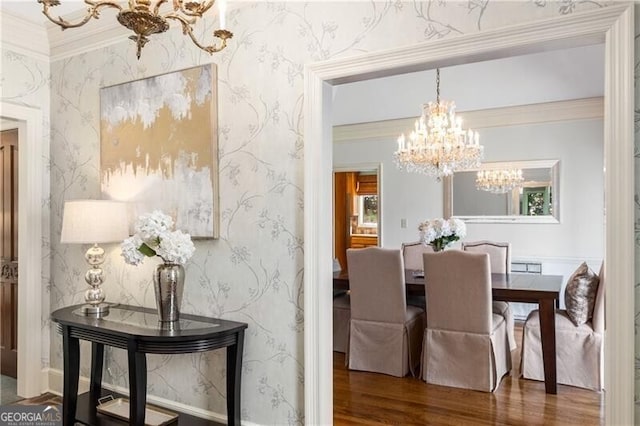 dining space with wallpapered walls, ornamental molding, wood finished floors, and an inviting chandelier