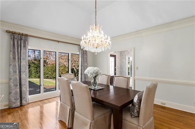 dining room featuring a healthy amount of sunlight, baseboards, wood finished floors, and ornamental molding