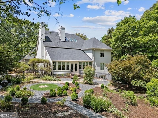 back of house with french doors, a chimney, a shingled roof, entry steps, and fence