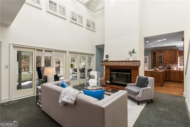 living area with baseboards, visible vents, french doors, and a glass covered fireplace