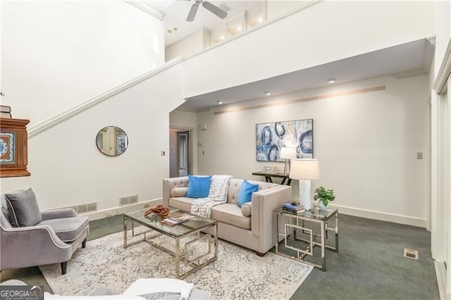 living room featuring a high ceiling, visible vents, ceiling fan, and baseboards