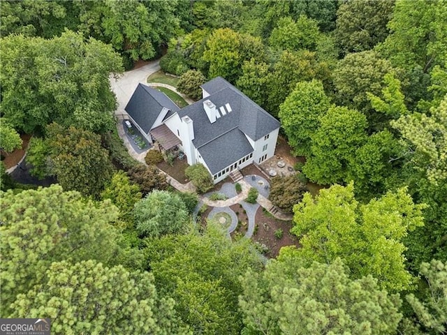 birds eye view of property featuring a forest view