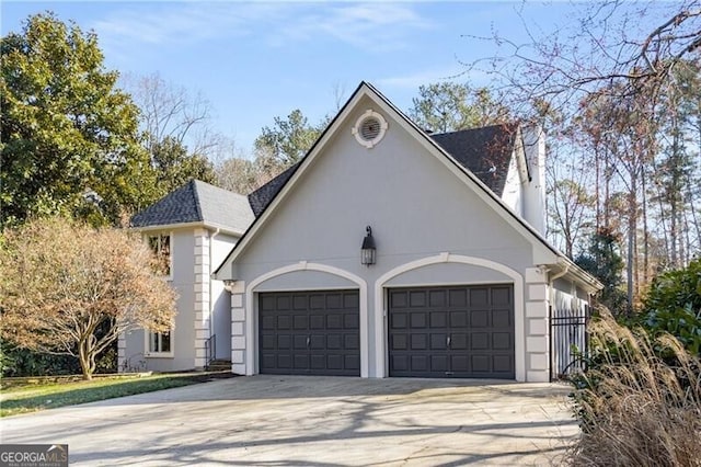 exterior space featuring driveway, a chimney, an attached garage, and roof with shingles