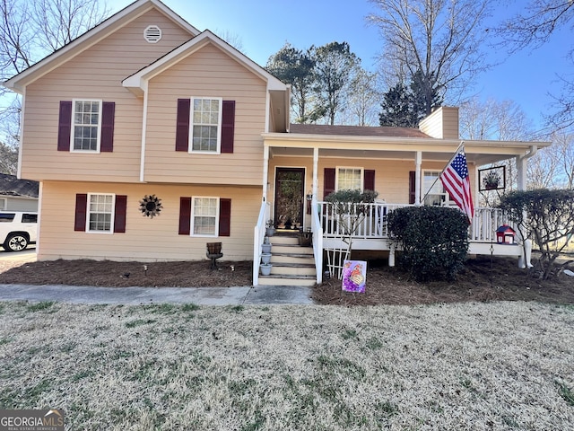 tri-level home with a porch and a chimney