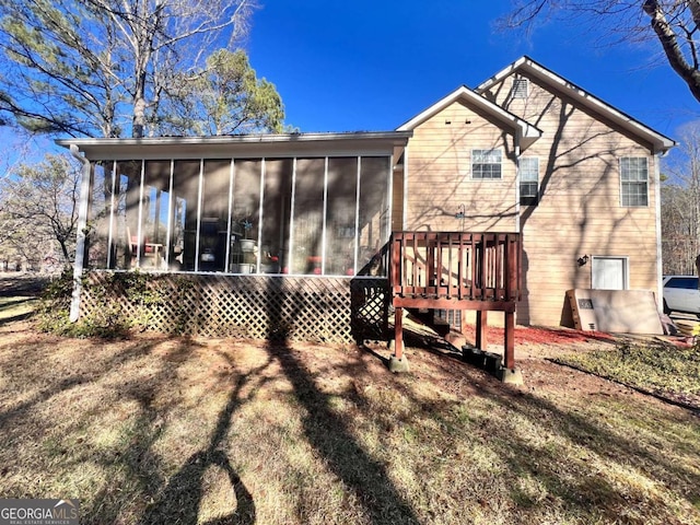 rear view of property with a deck and a sunroom