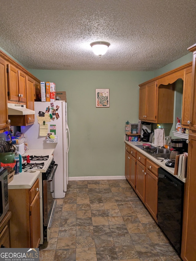 kitchen featuring under cabinet range hood, black dishwasher, gas range oven, light countertops, and baseboards