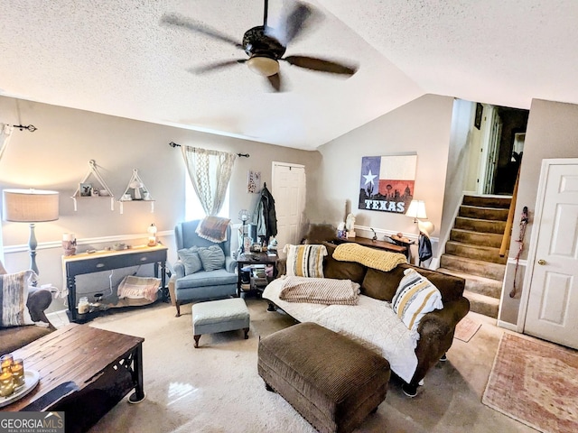 living room featuring stairs, a textured ceiling, lofted ceiling, and a ceiling fan