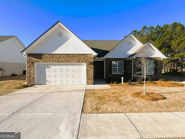 view of front of property featuring driveway, brick siding, and an attached garage