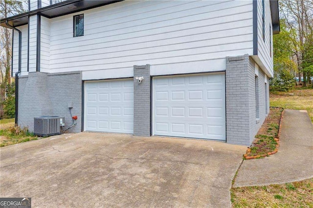 garage featuring driveway and central air condition unit