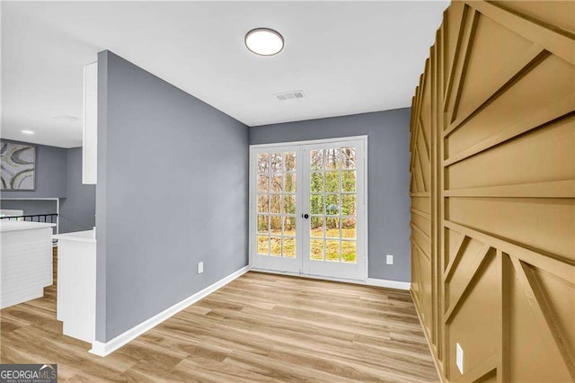 interior space featuring french doors, visible vents, baseboards, and light wood finished floors