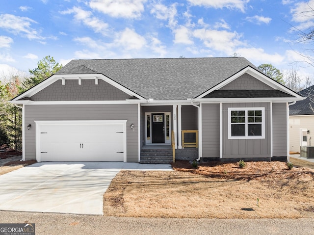 view of front of house with a garage, concrete driveway, and central AC