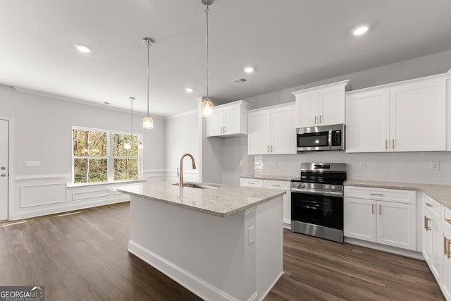 kitchen featuring a wainscoted wall, dark wood-style flooring, stainless steel appliances, and a sink