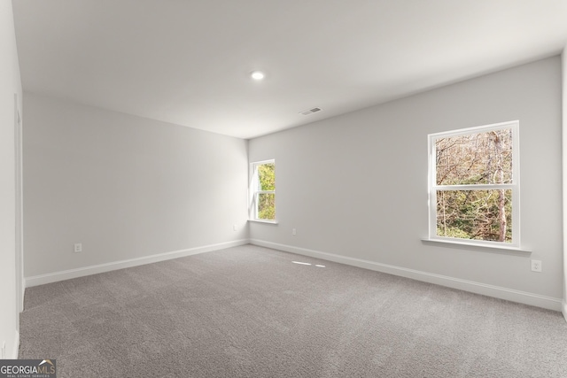 spare room with carpet, visible vents, baseboards, and recessed lighting