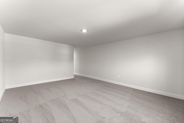 carpeted empty room featuring baseboards