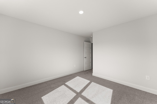 empty room featuring carpet floors, recessed lighting, and baseboards