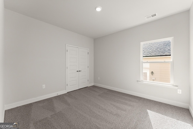 carpeted spare room with baseboards, visible vents, and recessed lighting