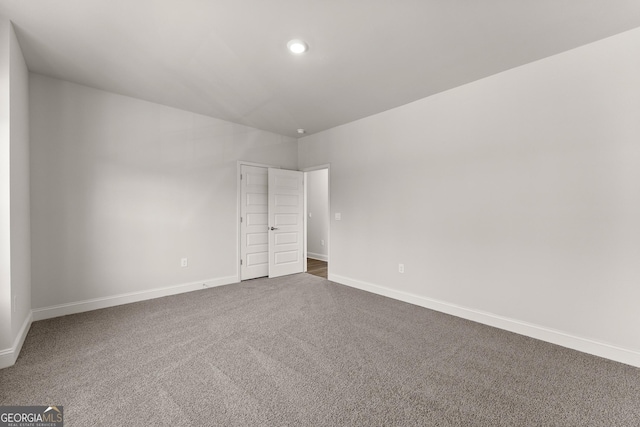 empty room with carpet, baseboards, and recessed lighting