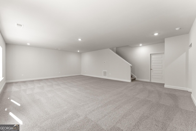 basement with stairway, visible vents, and recessed lighting