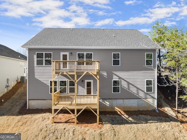 back of house featuring central AC, a shingled roof, and a wooden deck