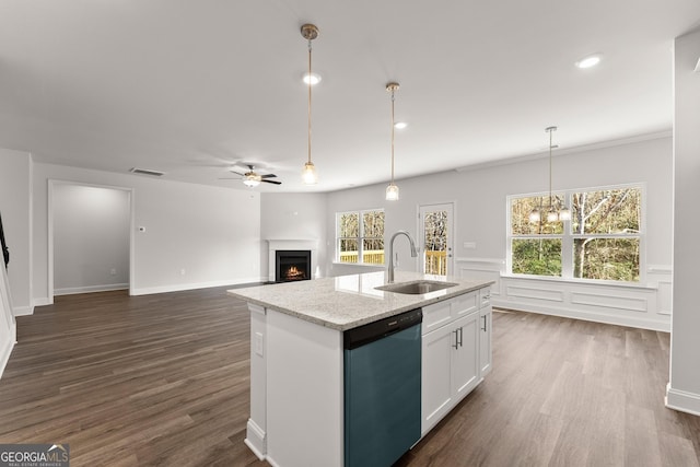 kitchen with a warm lit fireplace, dishwashing machine, dark wood-style floors, white cabinetry, and a sink