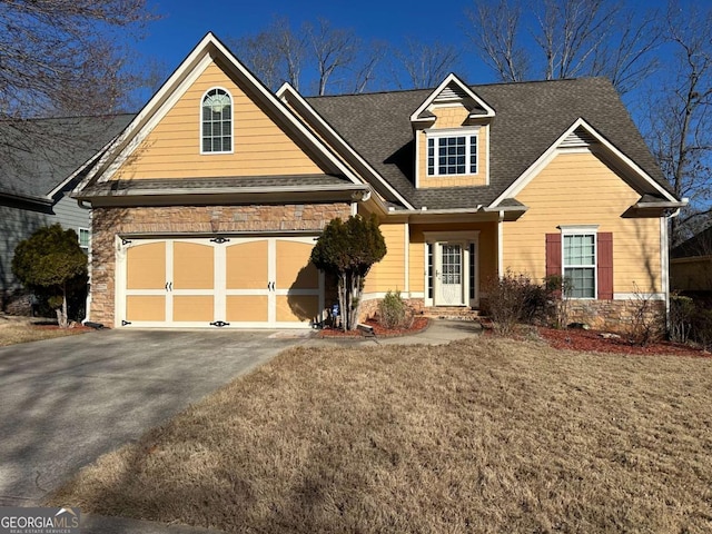 view of front of house featuring driveway, a front lawn, and roof with shingles