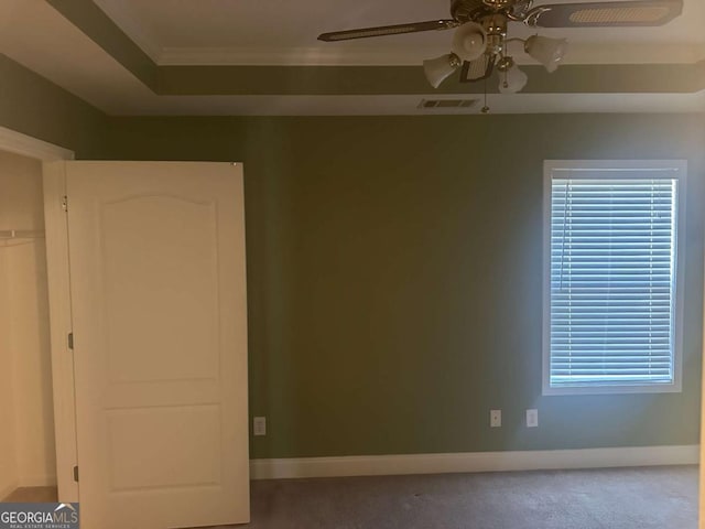 unfurnished room featuring baseboards, visible vents, a raised ceiling, and a ceiling fan