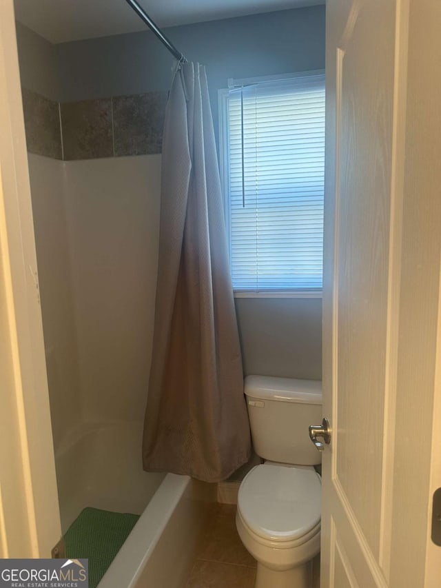 full bath with toilet, tile patterned floors, and a shower with shower curtain