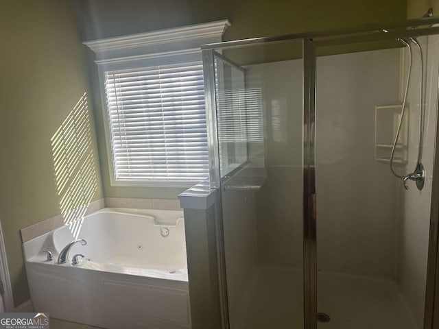 bathroom featuring a jetted tub and a shower stall