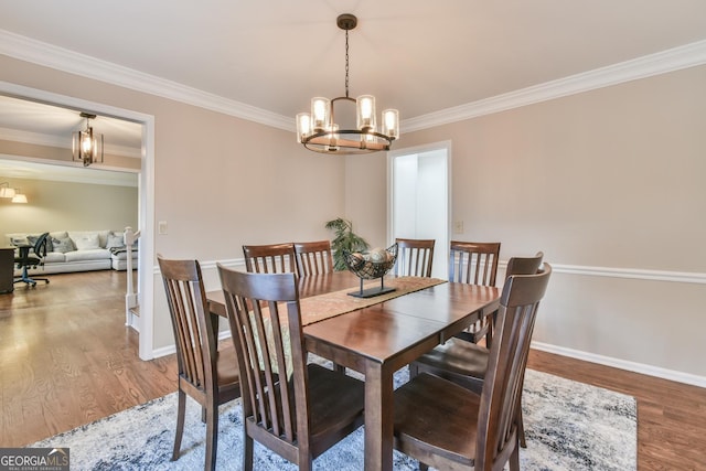 dining room with baseboards, crown molding, a chandelier, and wood finished floors