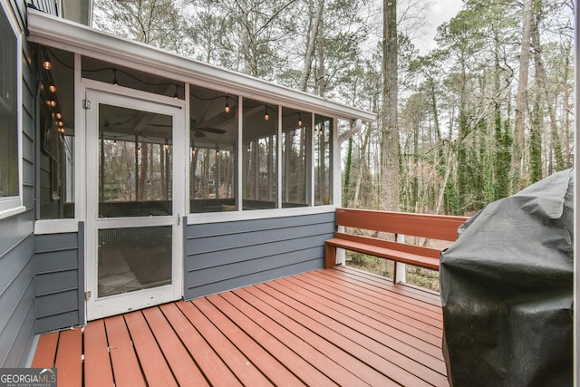 wooden terrace with a sunroom and area for grilling