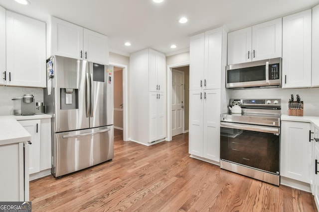 kitchen featuring stainless steel appliances, light wood-type flooring, light countertops, and white cabinets