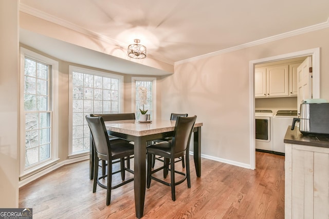 dining room with light wood finished floors, ornamental molding, independent washer and dryer, and plenty of natural light