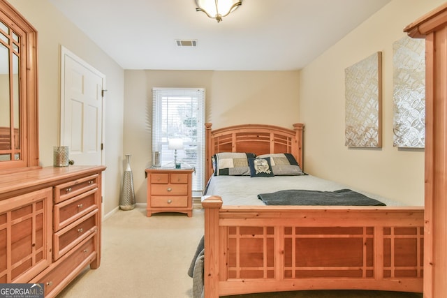 bedroom featuring visible vents, light carpet, and baseboards