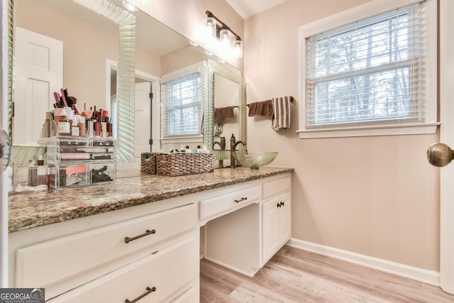 bathroom featuring vanity, baseboards, and wood finished floors