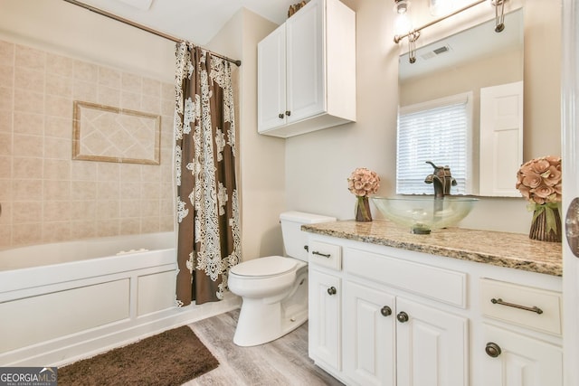 bathroom with toilet, wood finished floors, vanity, visible vents, and shower / bath combination with curtain