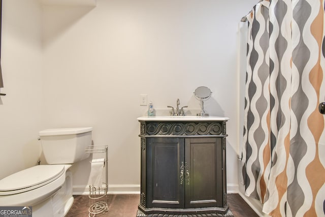 bathroom featuring toilet, baseboards, a shower with shower curtain, and vanity