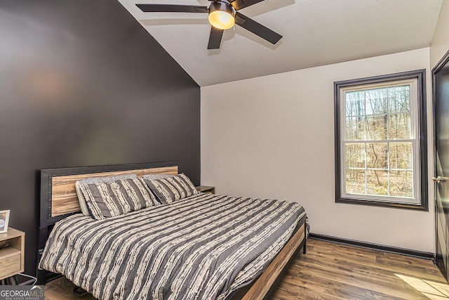 bedroom featuring a ceiling fan, light wood-type flooring, multiple windows, and vaulted ceiling