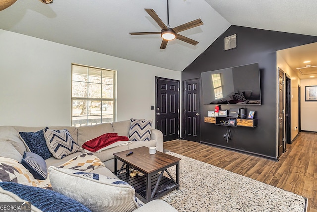 living area with attic access, vaulted ceiling, ceiling fan, and wood finished floors