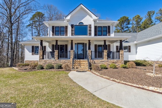 view of front facade with a porch, stone siding, and a front lawn